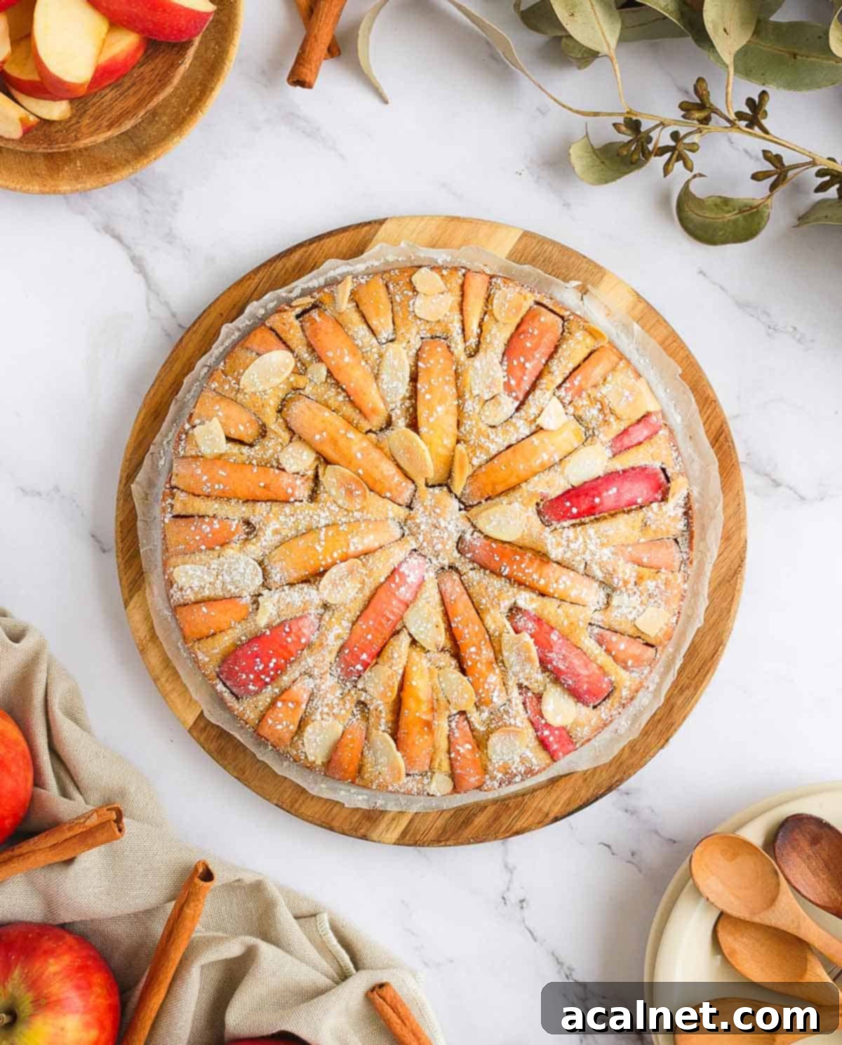 Effortless Gluten-Free Apple Cake 8 A festive arrangement featuring the Gluten-Free Apple Cake with Applesauce surrounded by fresh apples, autumn leaves, and small plates, highlighting its seasonal appeal.