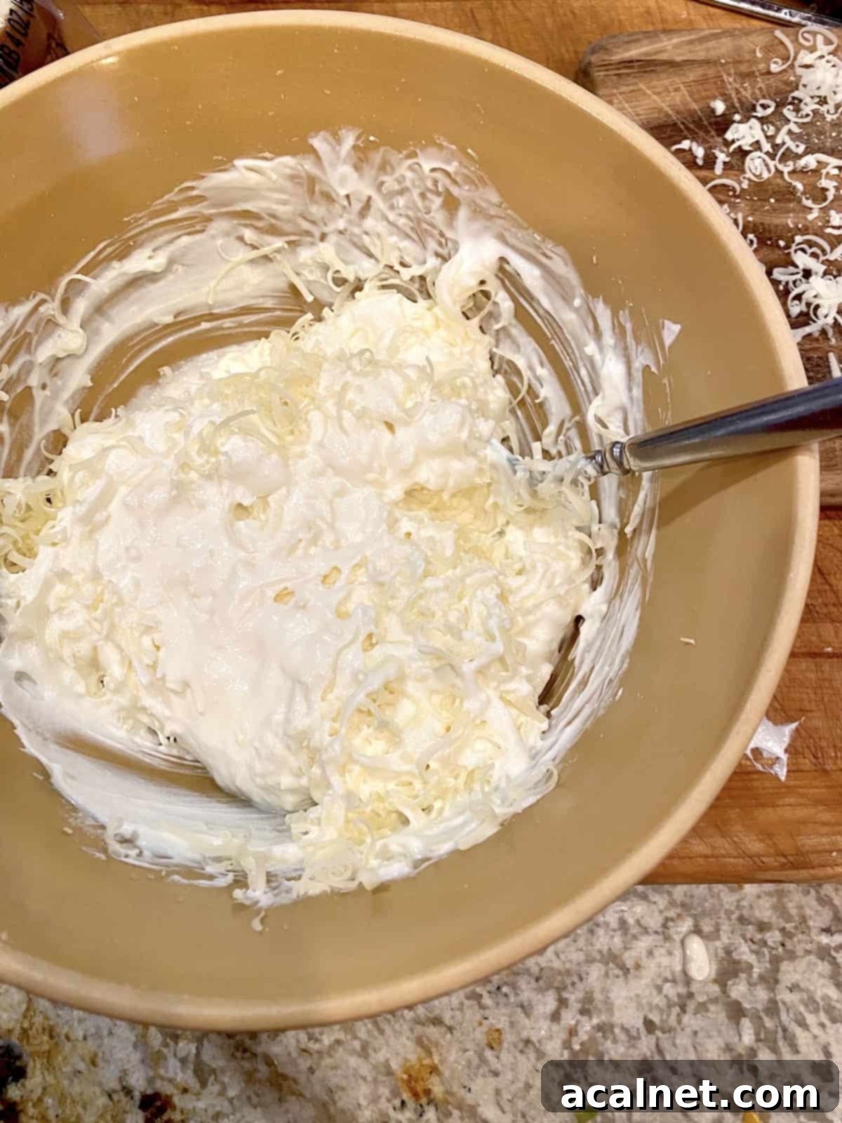 Creamy dairy ingredients in a small bowl, ready to be blended for the artichoke dip.
