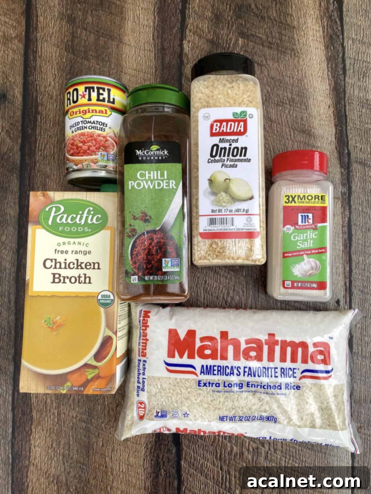Ingredients for Mexican rice displayed on wooden table.