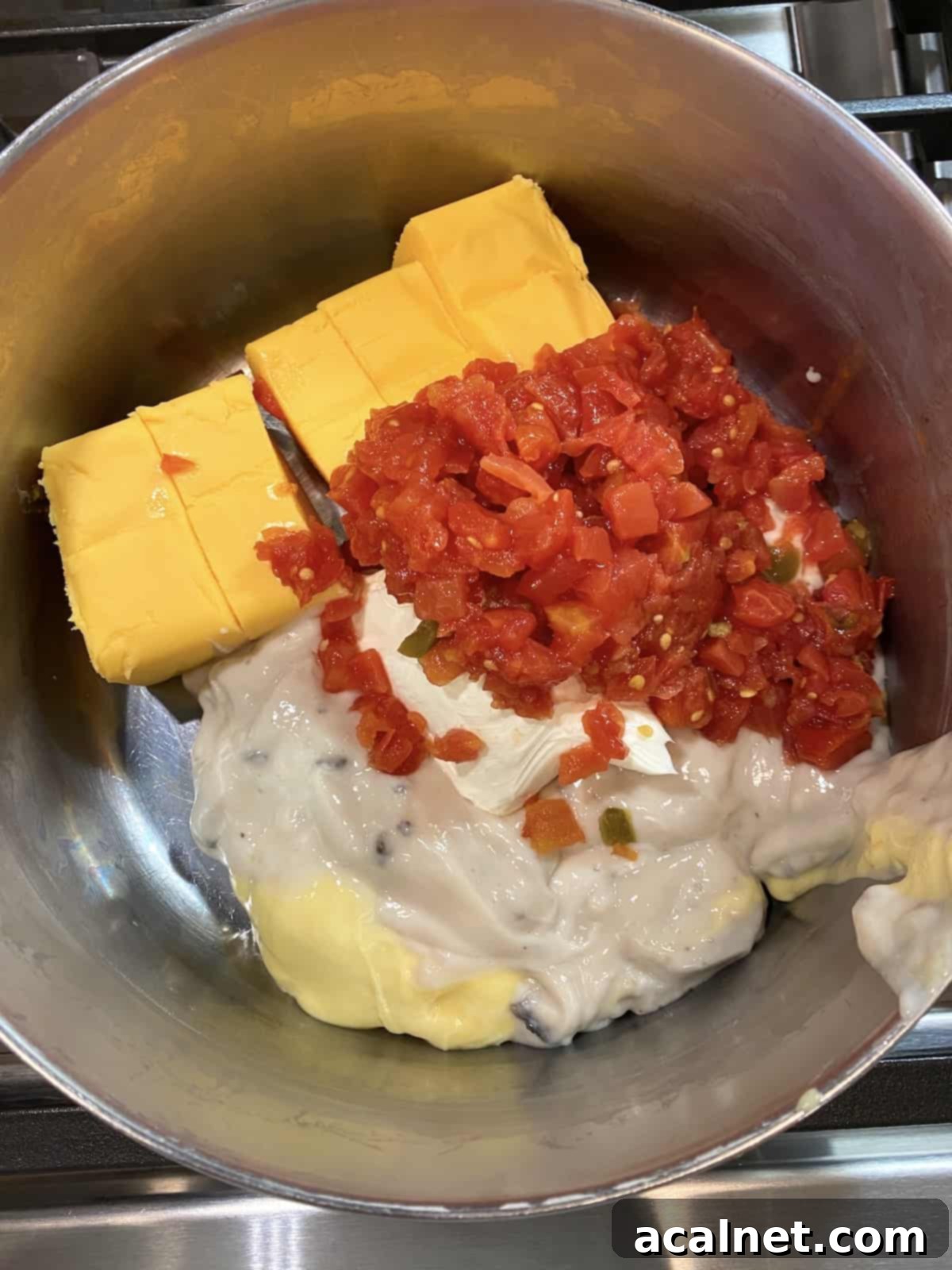 Velveeta, creamed soup, cream cheese and Rotel in a pot on the stove.