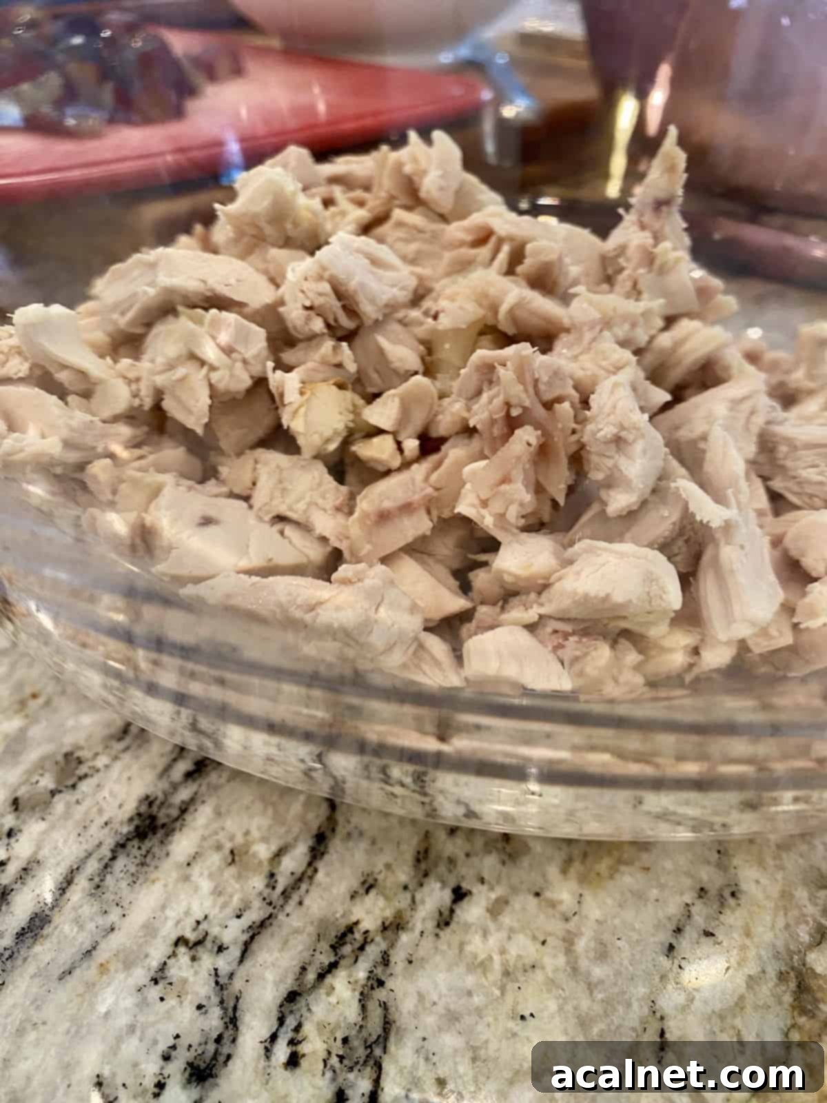 Diced and shredded cooked chicken in a bowl.
