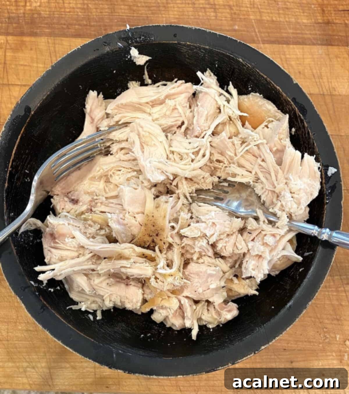 Chicken chicken in a bowl on a cutting board.