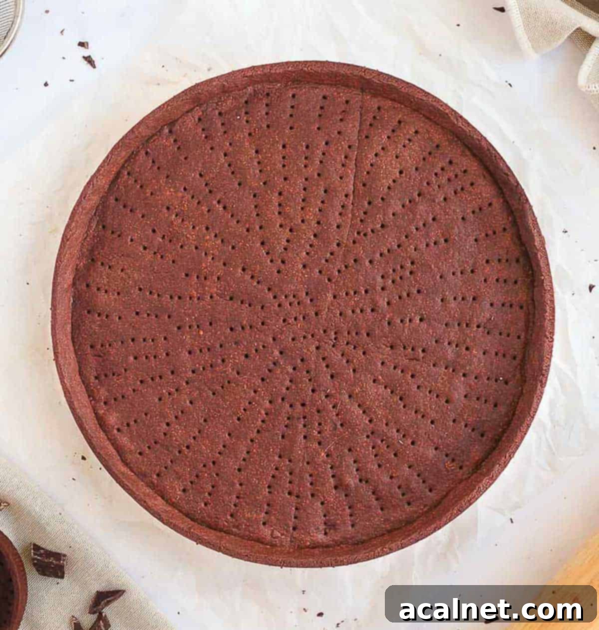 Baked pie crust seen from above on a white surface.