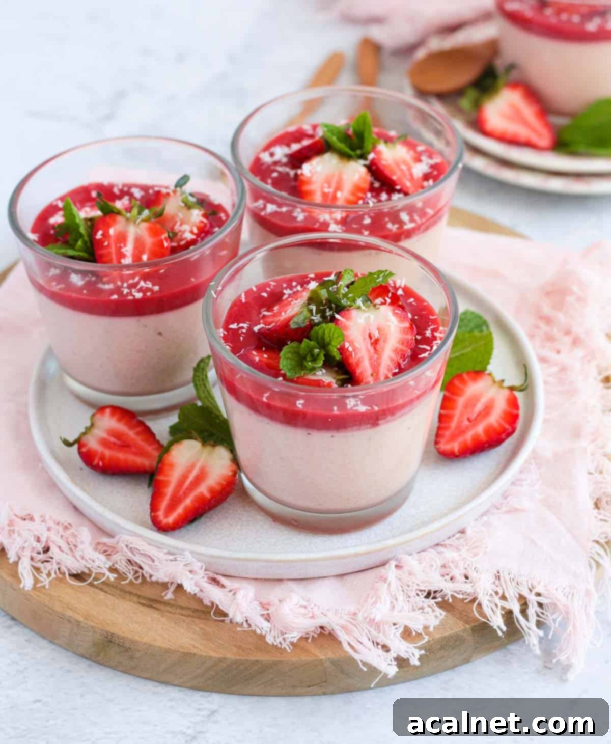 Homemade Strawberry Panna Cotta with Fresh Strawberry Sauce 7 Three panna cottas on a white plate.