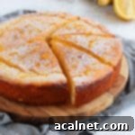Ricotta cake with 3 slices cut out on a wooden board over a grey napkin.