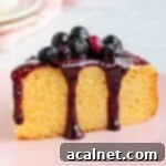 A slice of cake drizzled with the blueberry sauce.