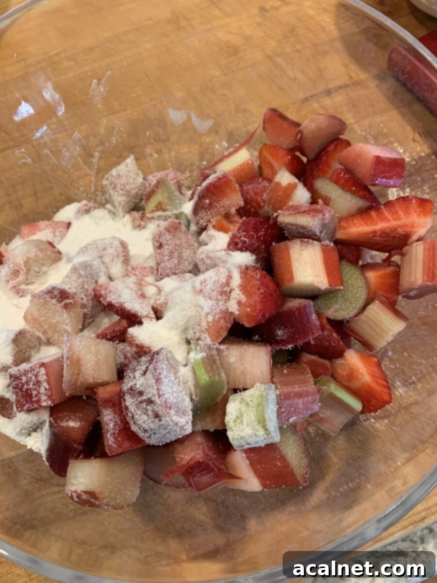 Diced strawberries and rhubarb in a bowl with sugar and flour. 