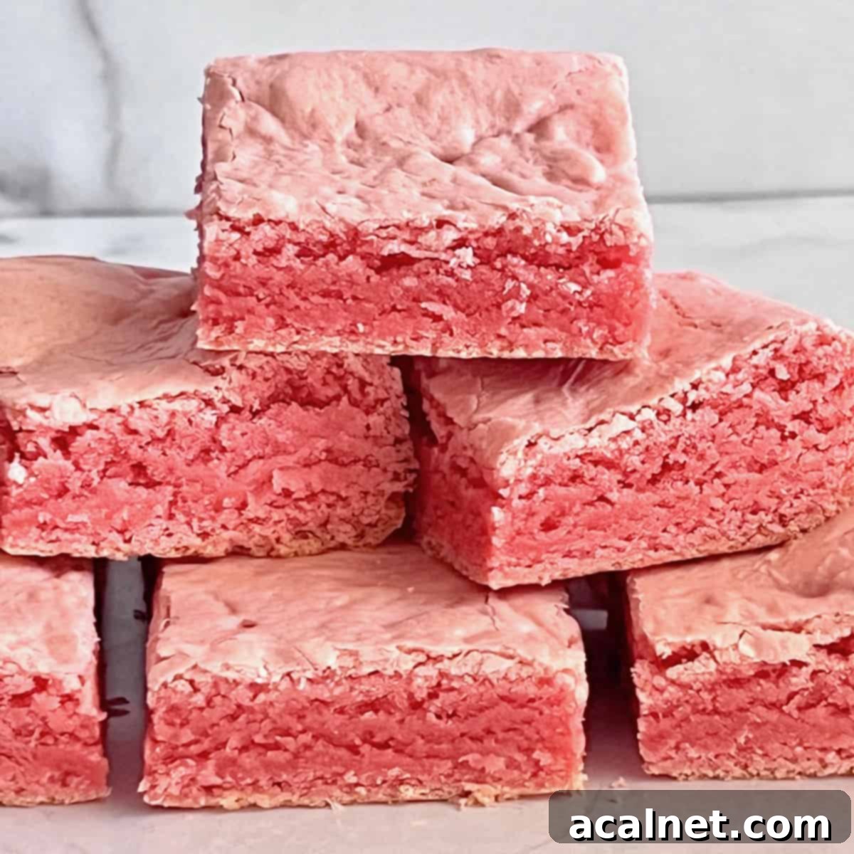 Chewy pink strawberry brownies made from cake mix.