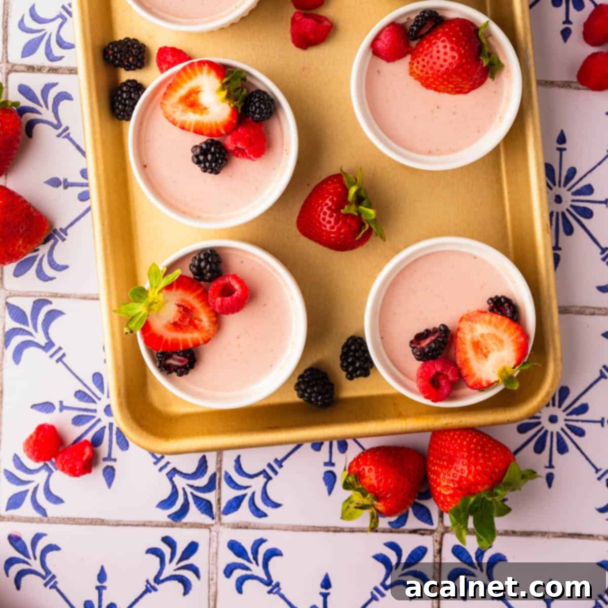 Smooth, creamy homemade strawberry panna cotta in a glass, garnished with fresh strawberries.