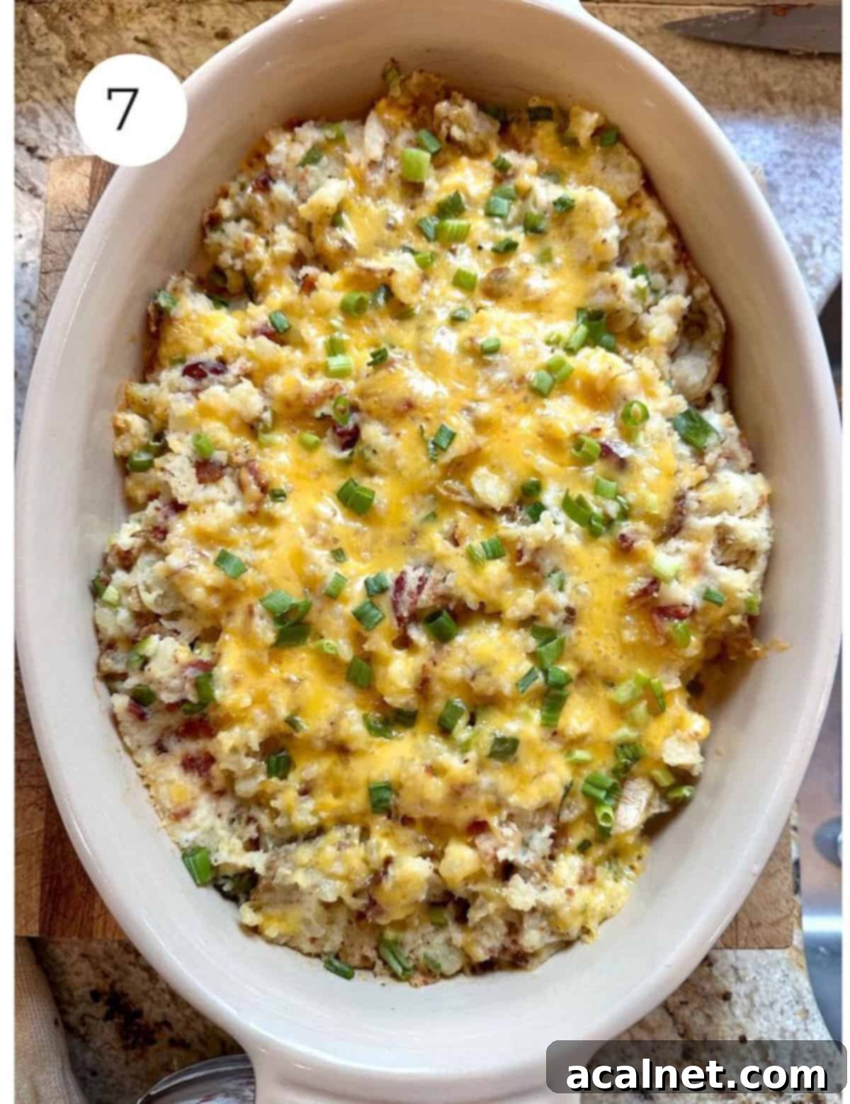 Baked, twice baked mashed potatoes in a casserole dish with melted cheese on top.