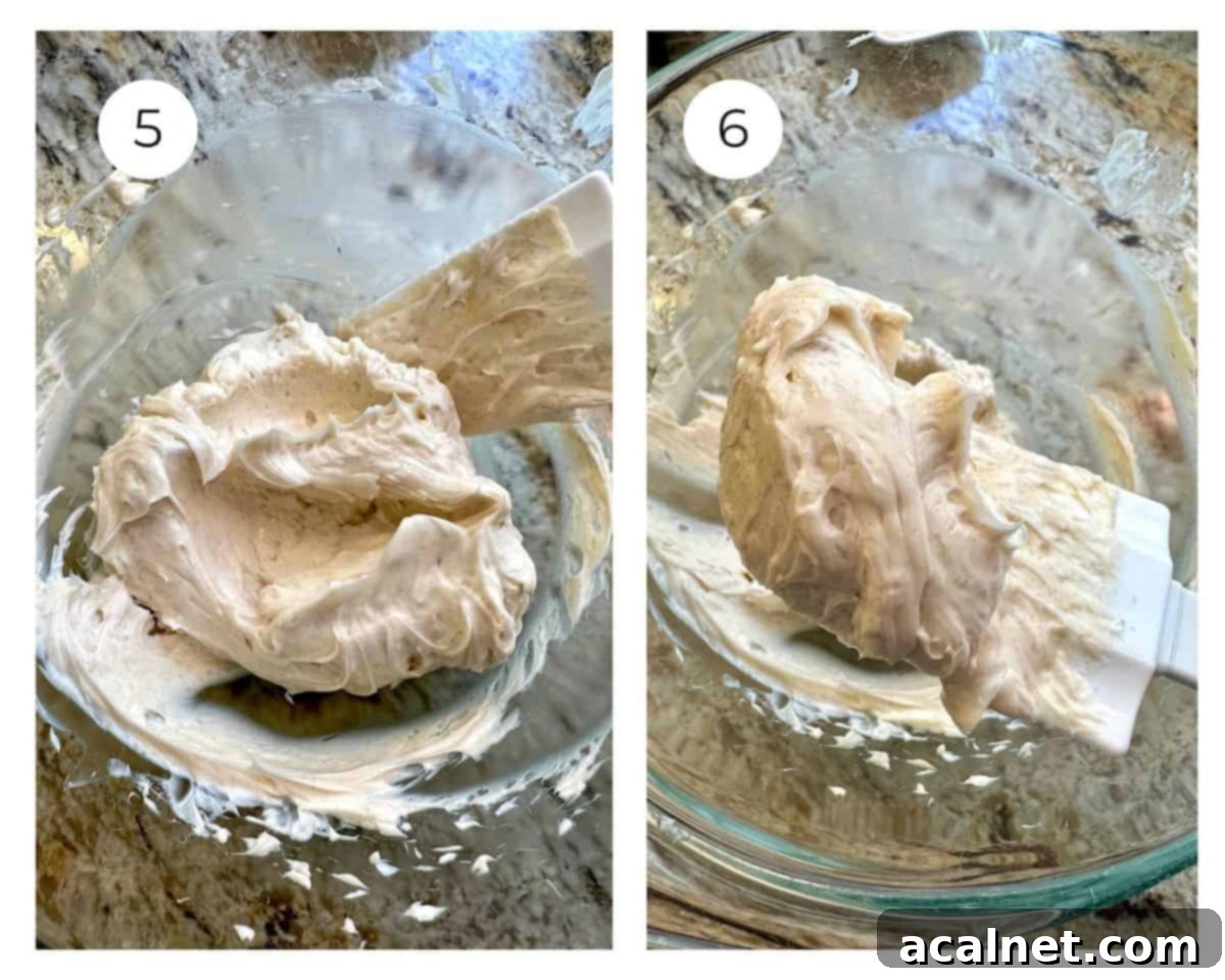 Smooth, perfectly whipped honey butter in a bowl, with a rubber spatula scooping a generous portion, clearly illustrating its creamy and inviting texture.