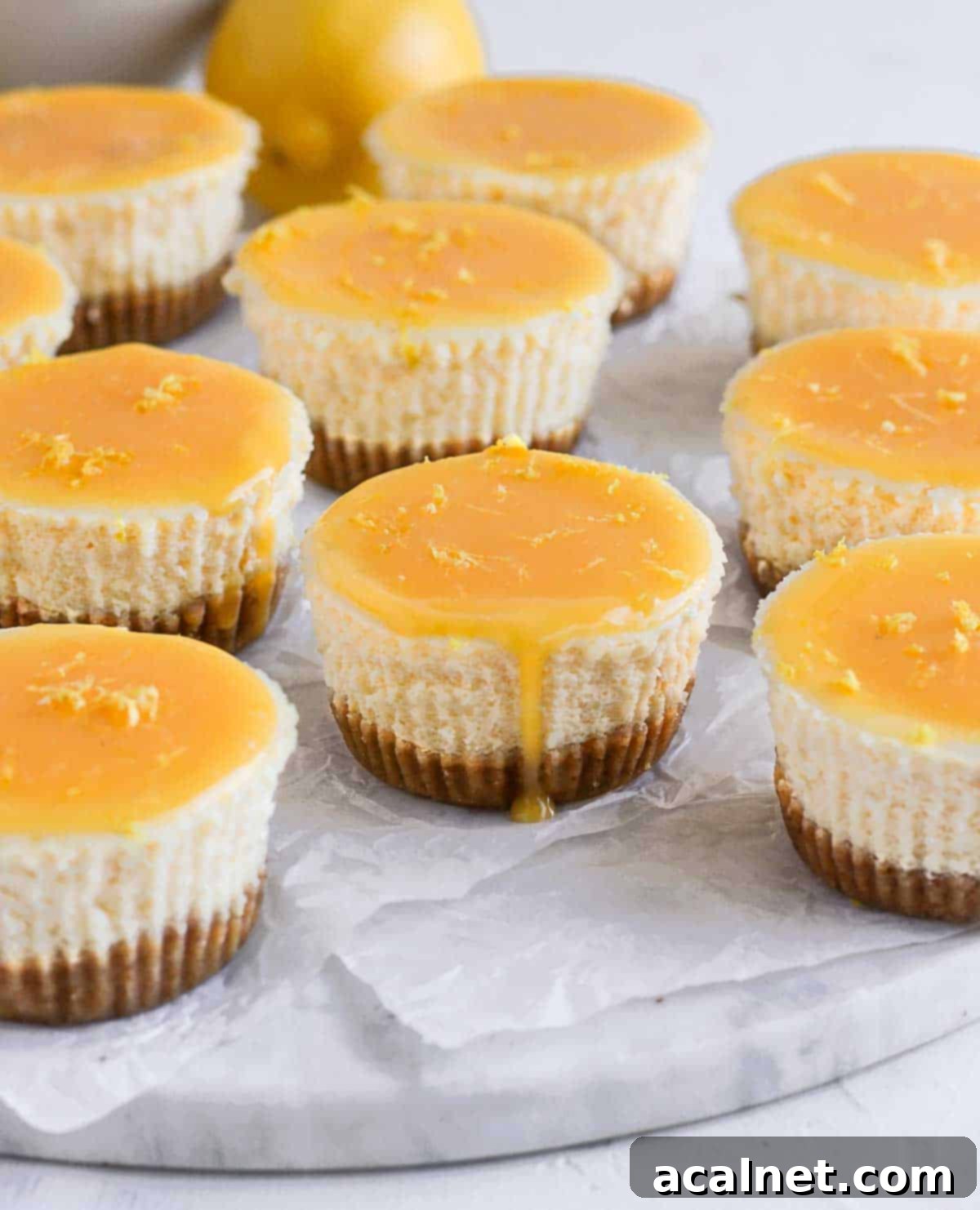 Zesty Mini Lemon Curd Cheesecakes 8 Fresh lemon curd being poured over a mini cheesecake, creating a glossy, vibrant topping.