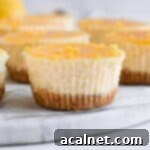 Zesty Mini Lemon Curd Cheesecakes 10 Close up on one mini lemon cheesecake over a marble board.