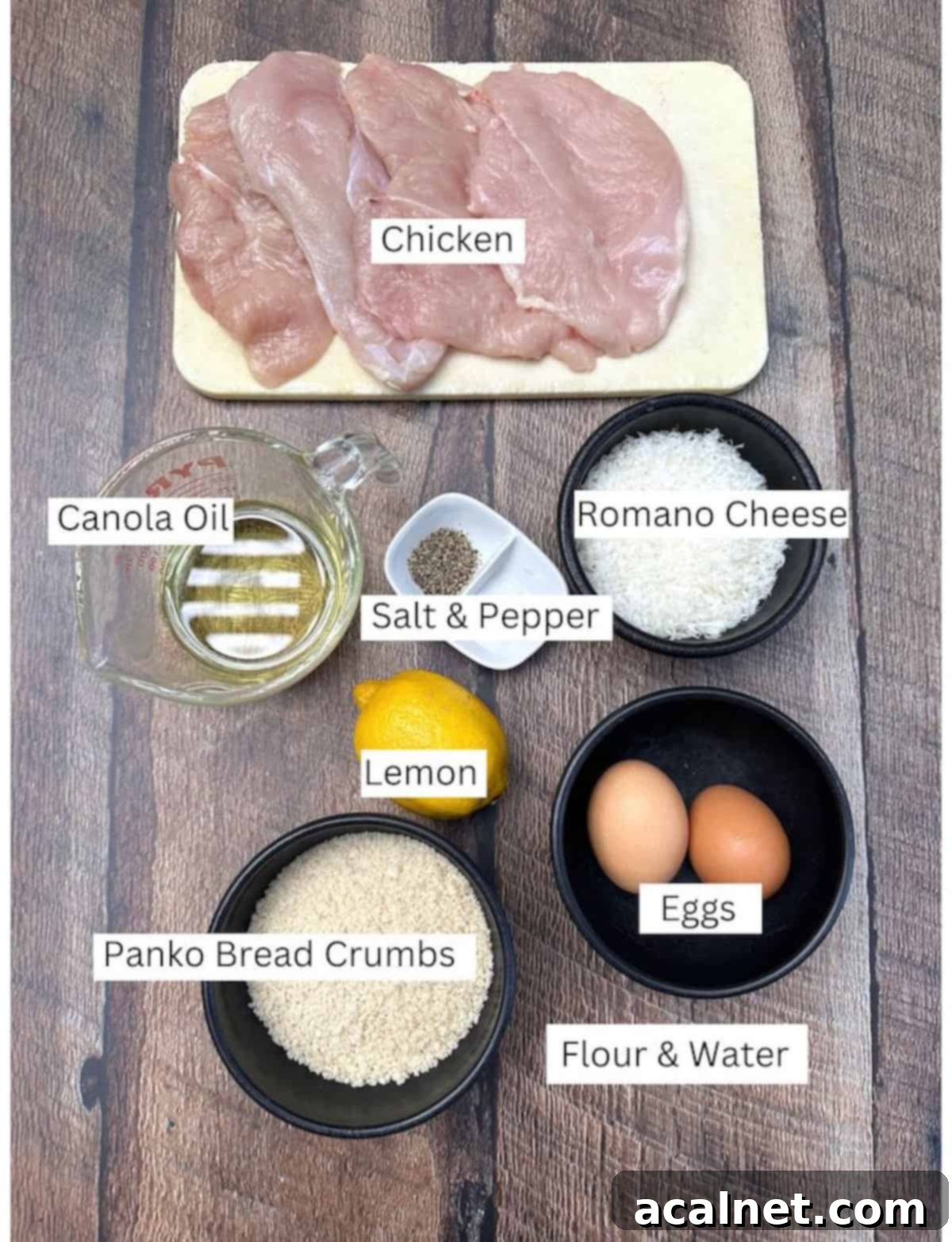 Ingredients for chicken Romano in small dishes and bowls on a wooden plank, ready for breading.