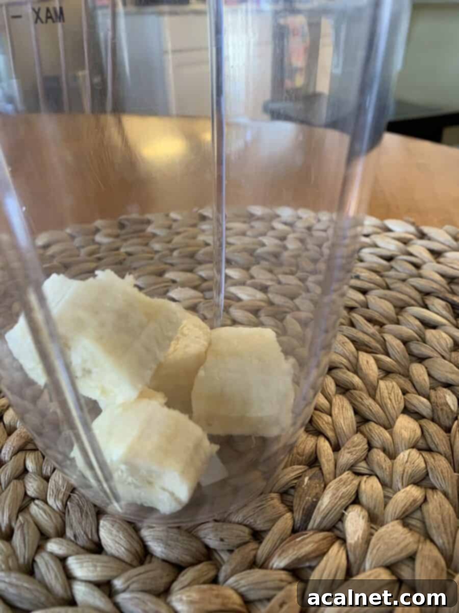 Half of a ripe banana added to a blender cup.