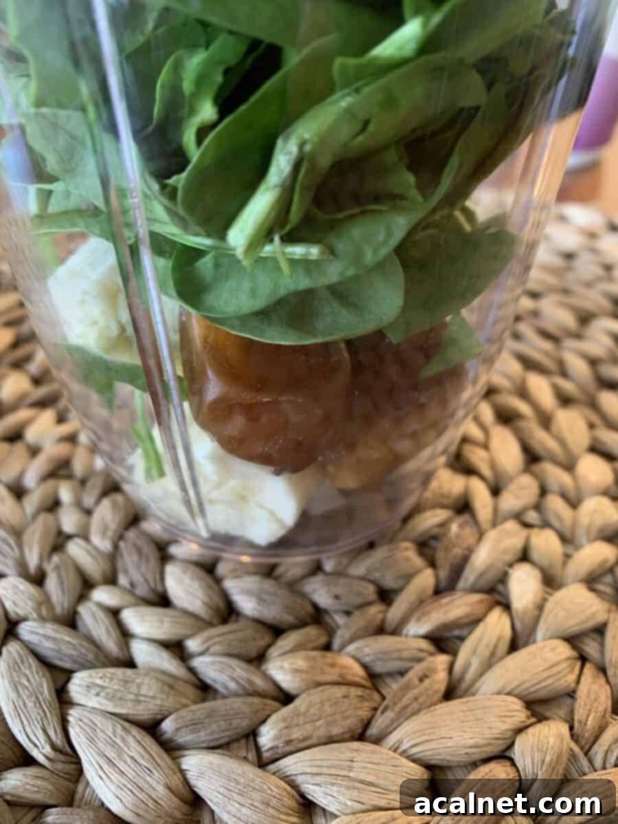 Spinach, dates, and banana in a blender cup, ready for blending.