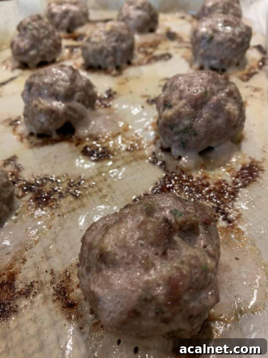 Cooked meatballs on a baking sheet. 