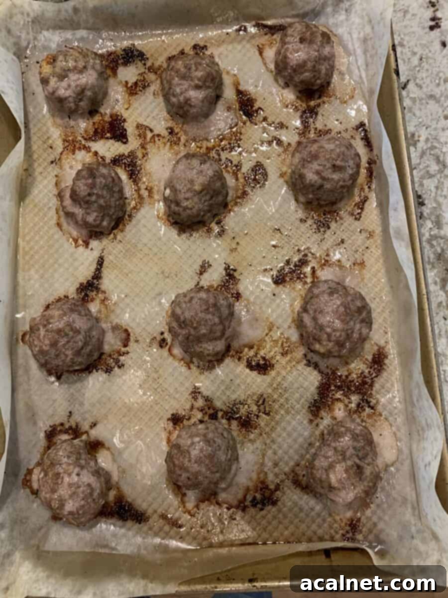 Twelve baked meatballs on a pan