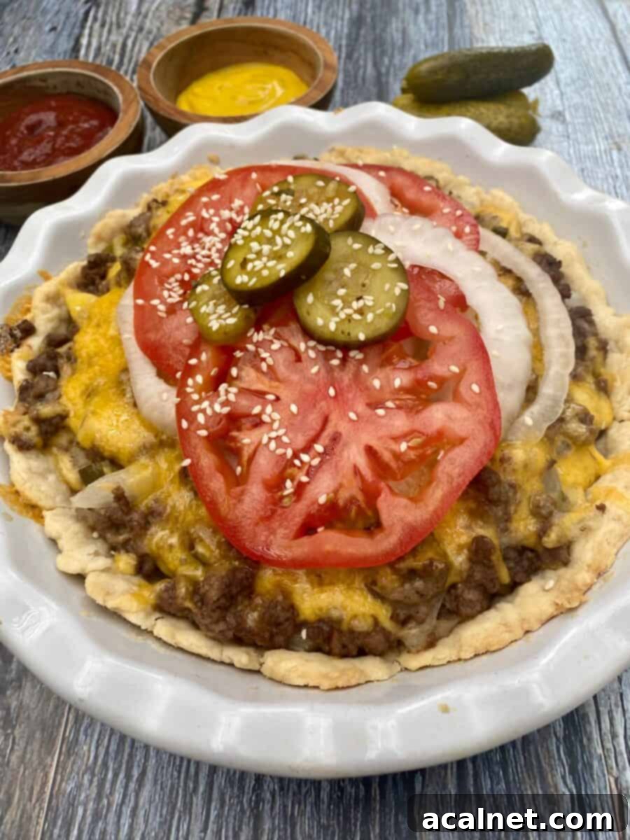 A slice of cheeseburger pie served in a pie plate, with small dishes of ketchup and mustard alongside, ready to be enjoyed.