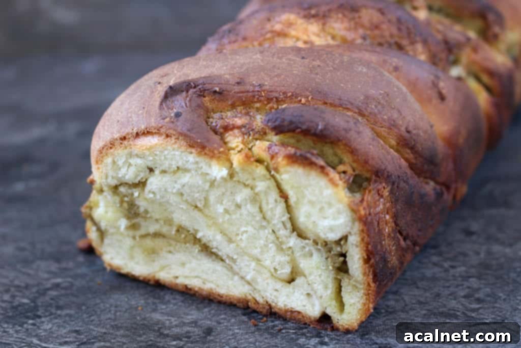 Overhead view of a Pesto Mozzarella Babka Bread loaf, highlighting the golden crust and hints of green filling.