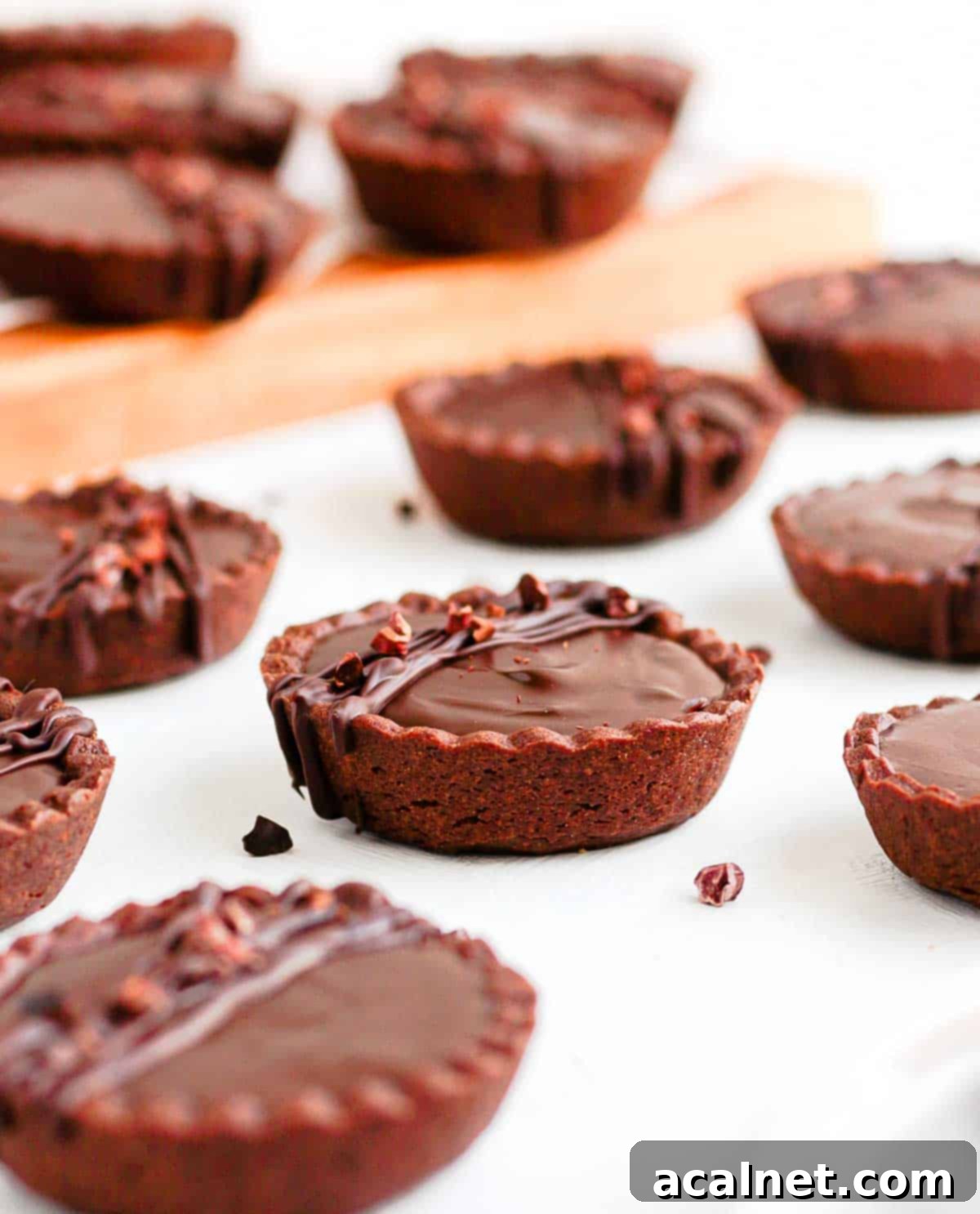 Tartlets on a white surface and over a wooden board.