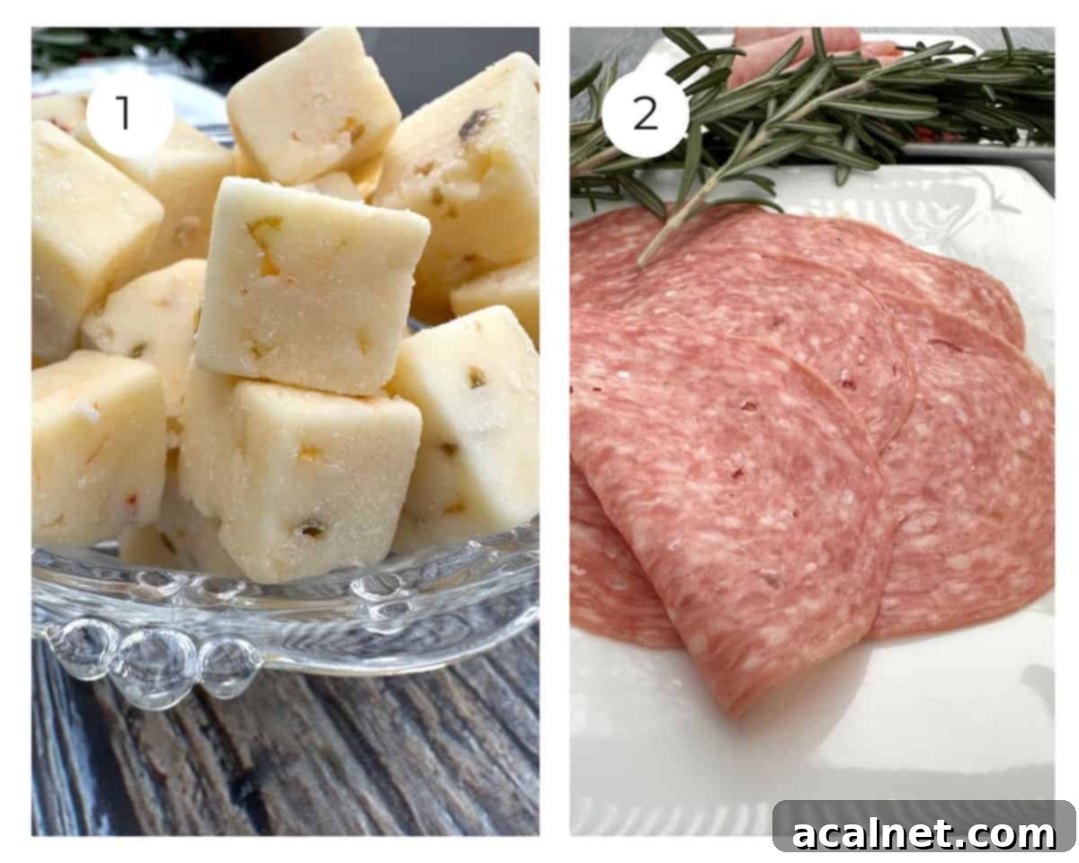 Cubes of cheese and several slices of salami with rosemary on the side.