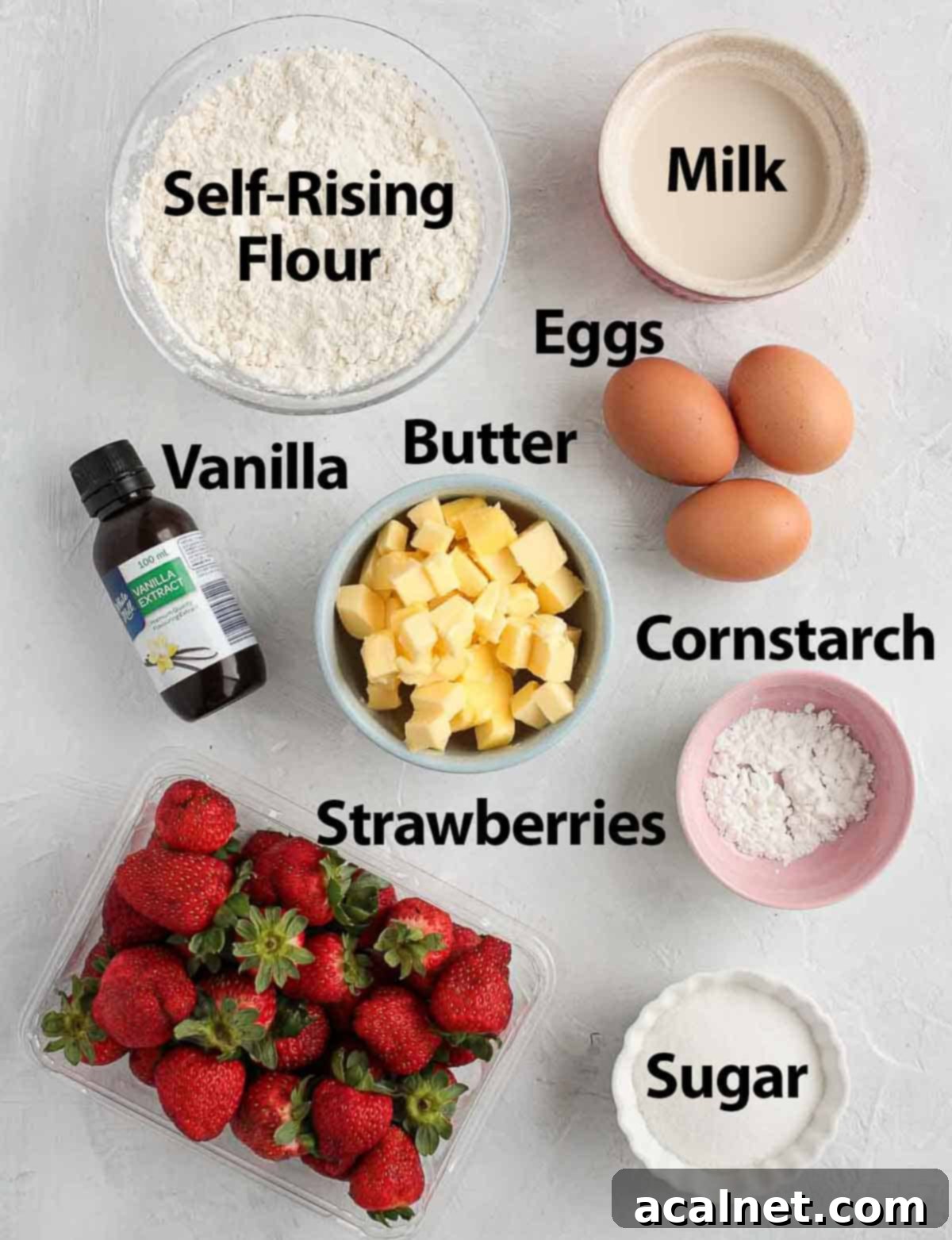 A collection of ingredients for Strawberry Upside Down Cake laid out on a white surface.