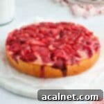A beautiful Strawberry Upside Down Cake on a round marble board.