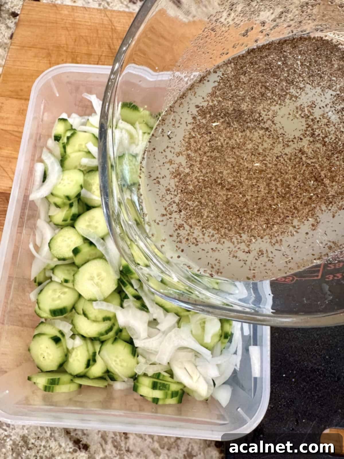 Pouring brine over cucumber and onion slices.