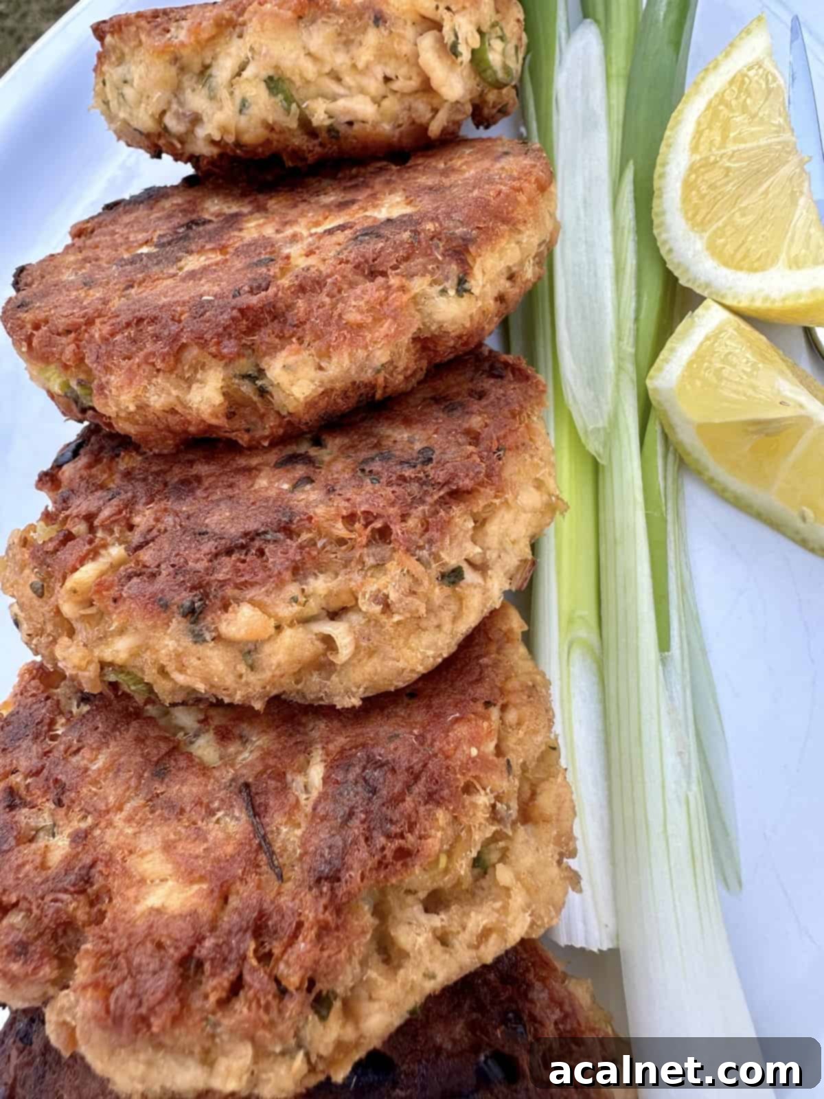 Cooked salmon patties on a plate with garnishes.