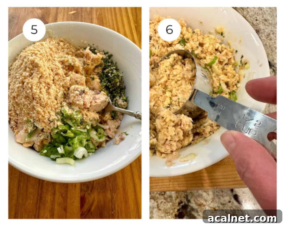 Salmon patty ingredients in a bowl and being spooned up with a measuring scoop.