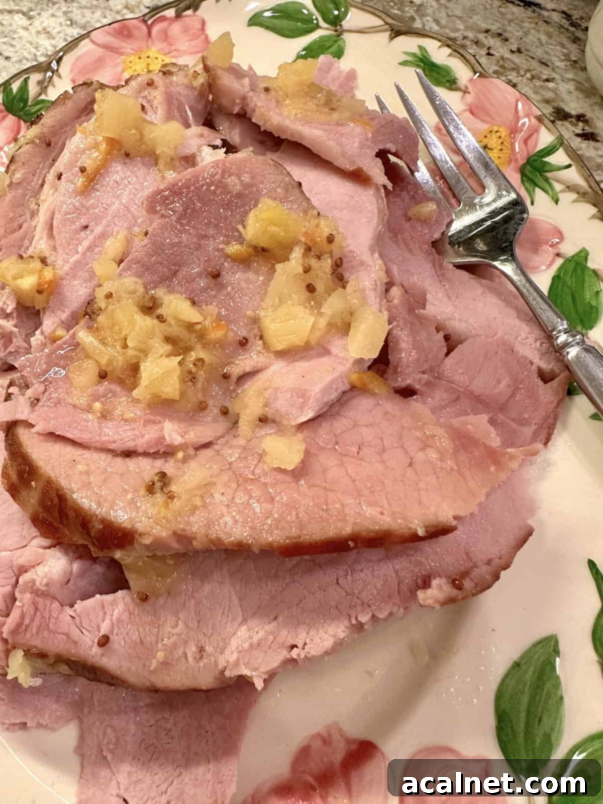 Deliciously sliced slow cooker ham with pineapple glaze on a white serving plate, ready to be enjoyed.