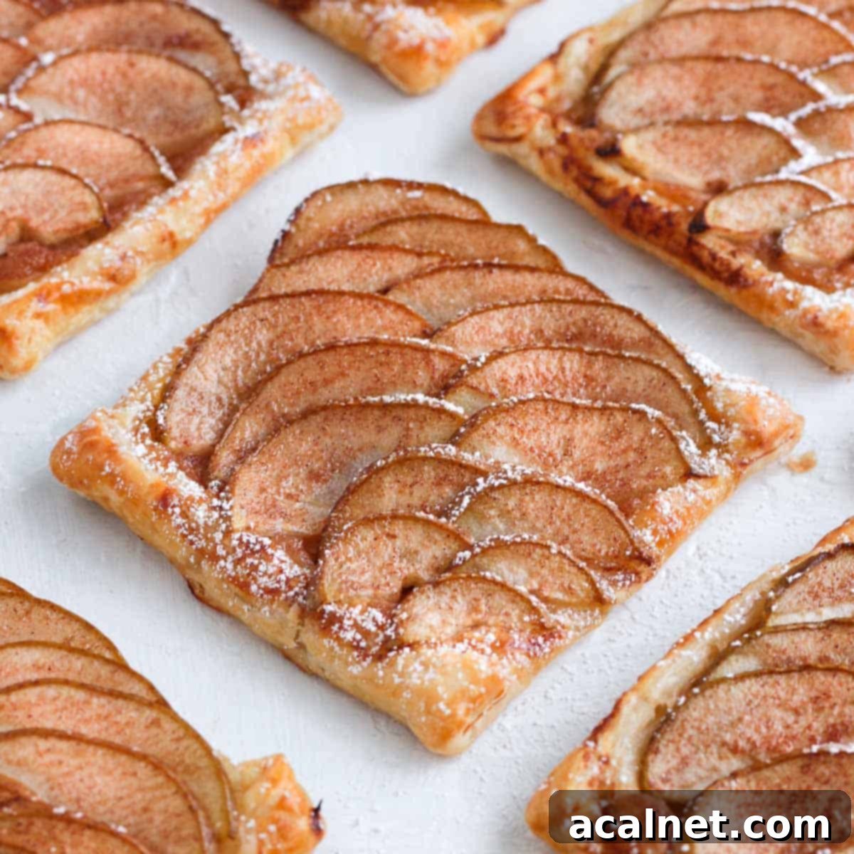 Close up on one pear tartlet on a white surface.