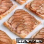 Close up on one pear tartlet on a white surface.