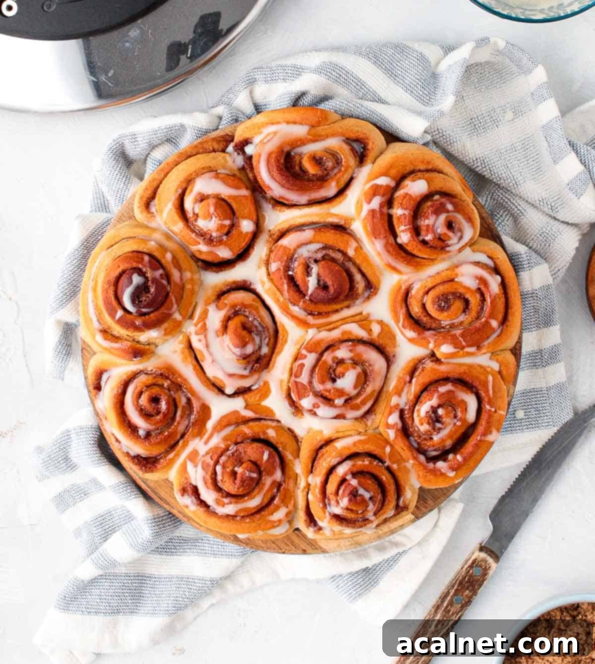 Iced cinnamon rolls on a wooden board from above.