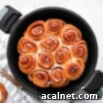 Cinnamon rolls inside the remoska bowl from above, freshly baked and glazed.