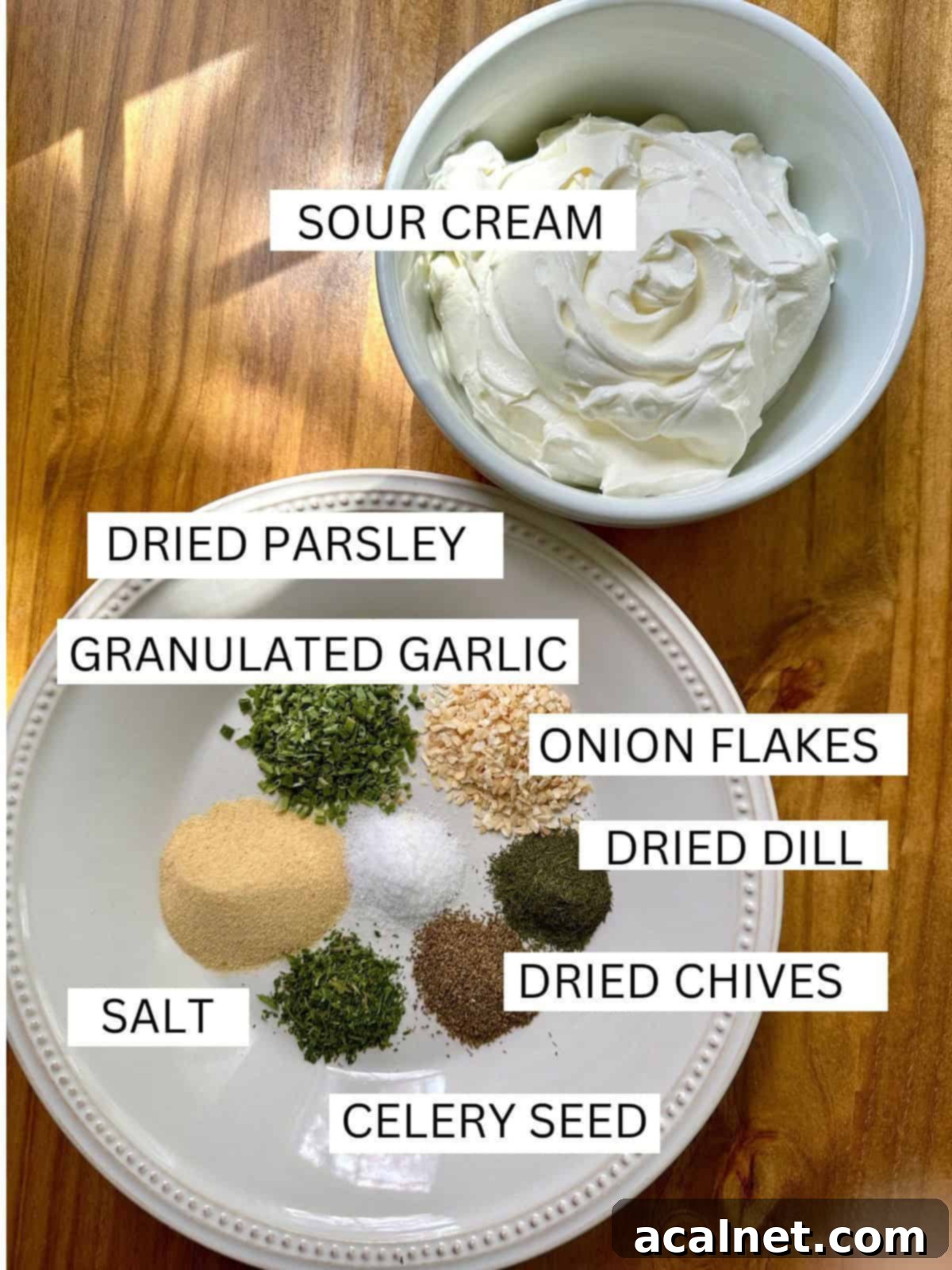 Neatly arranged ingredients for homemade herb and garlic dip, including various dried herbs and spices in labeled containers on a wooden table.