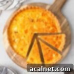 Flatlay of the pumpkin quiche on a wooden board with 3 slices cut off.