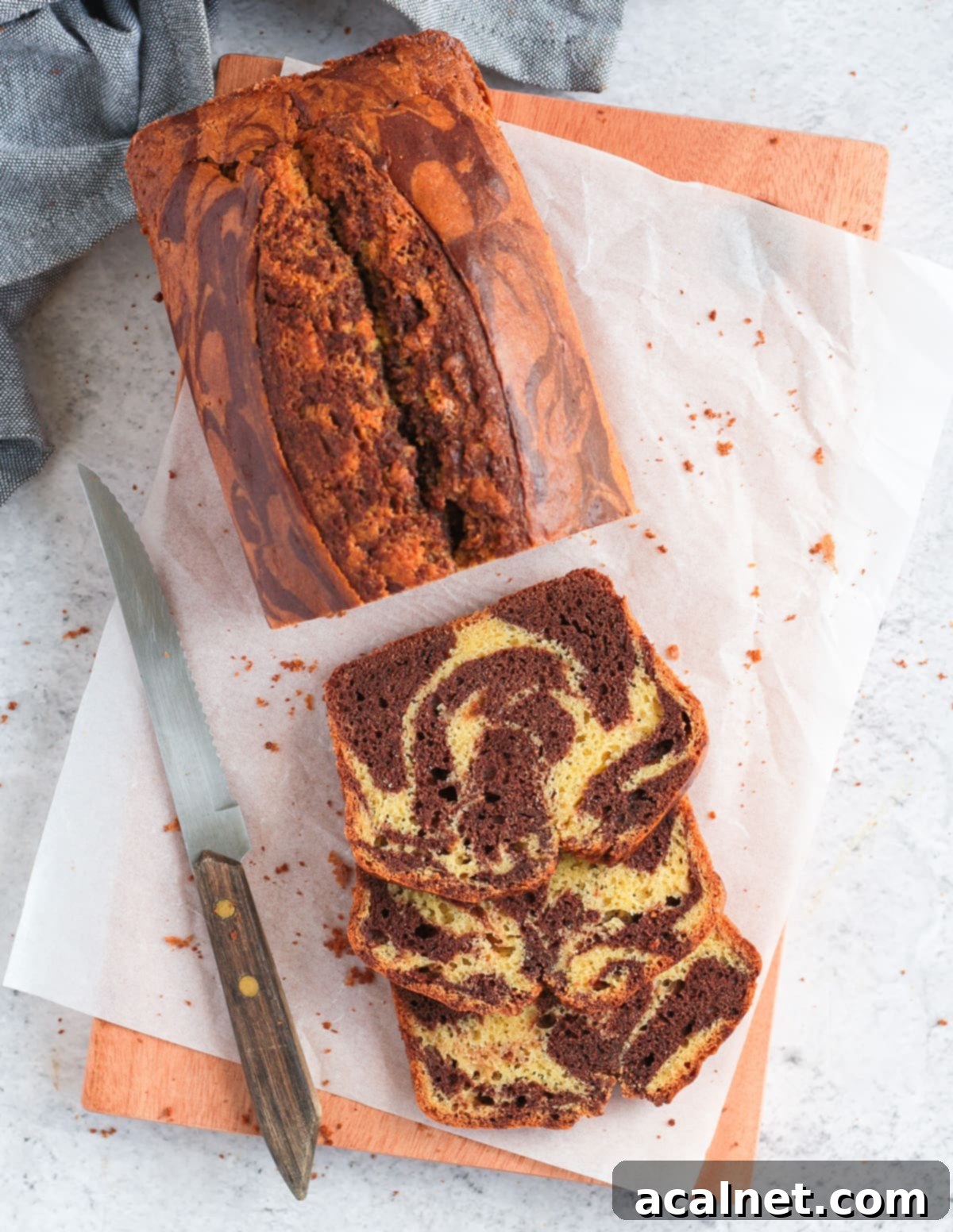 Slices of a marble loaf cake on a wooden board, highlighting a baked good achievable with simple tools.