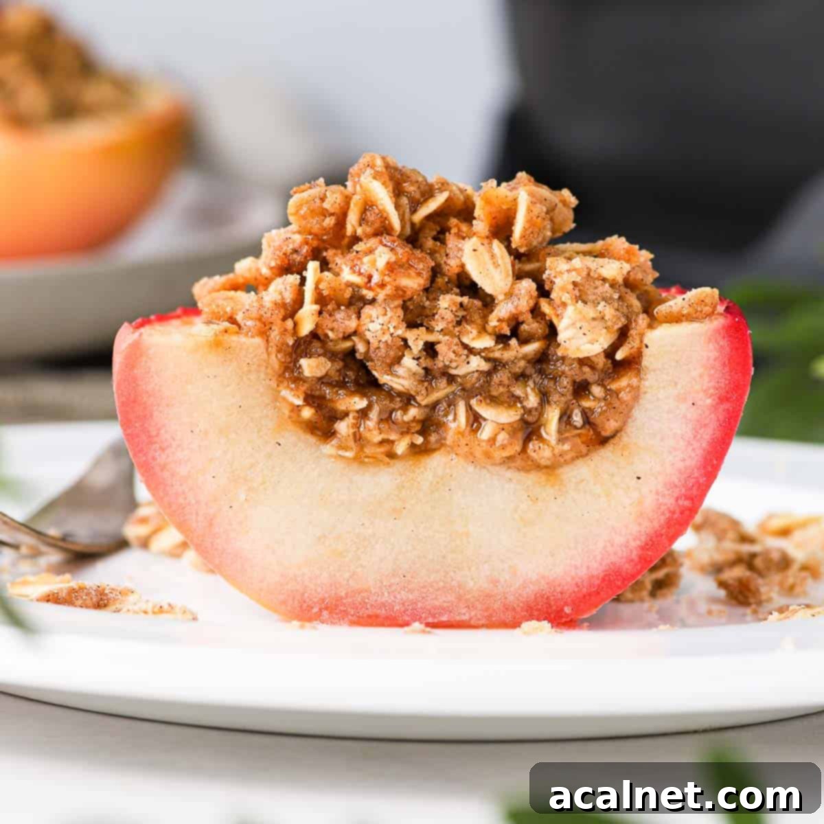 Remoska's Golden Crumble-Baked Apples 2 A delicious baked apple with golden crumble topping, sliced in half to show the soft, tender apple inside.