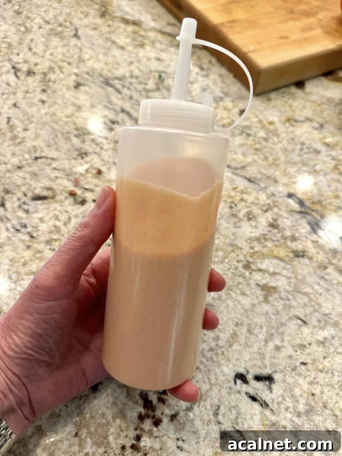 Ultimate Fry Dip 8 A clear squeeze bottle filled with the creamy, pinkish French fry sauce, ready for easy dispensing. The sauce looks smooth and perfectly blended.