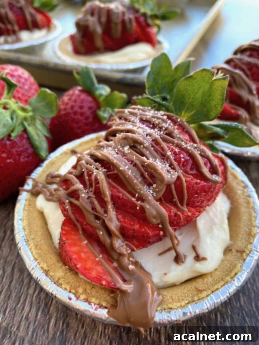 Another view of a mini strawberry pie with chocolate drizzle and fresh berries.