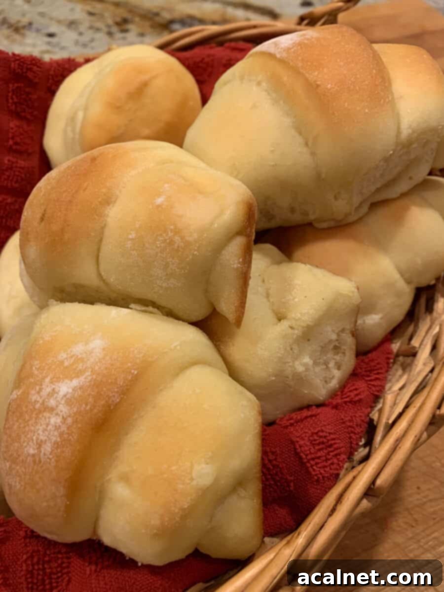 Beautifully baked potato rolls stacked in a rustic serving basket, with a light dusting of flour