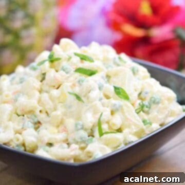 A large bowl of Hawaiian Potato Salad, a unique blend of potatoes and macaroni, served outdoors.