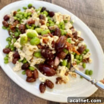 A vibrant Easy Edamame Salad presented on a plate, with a large spoon serving a portion.
