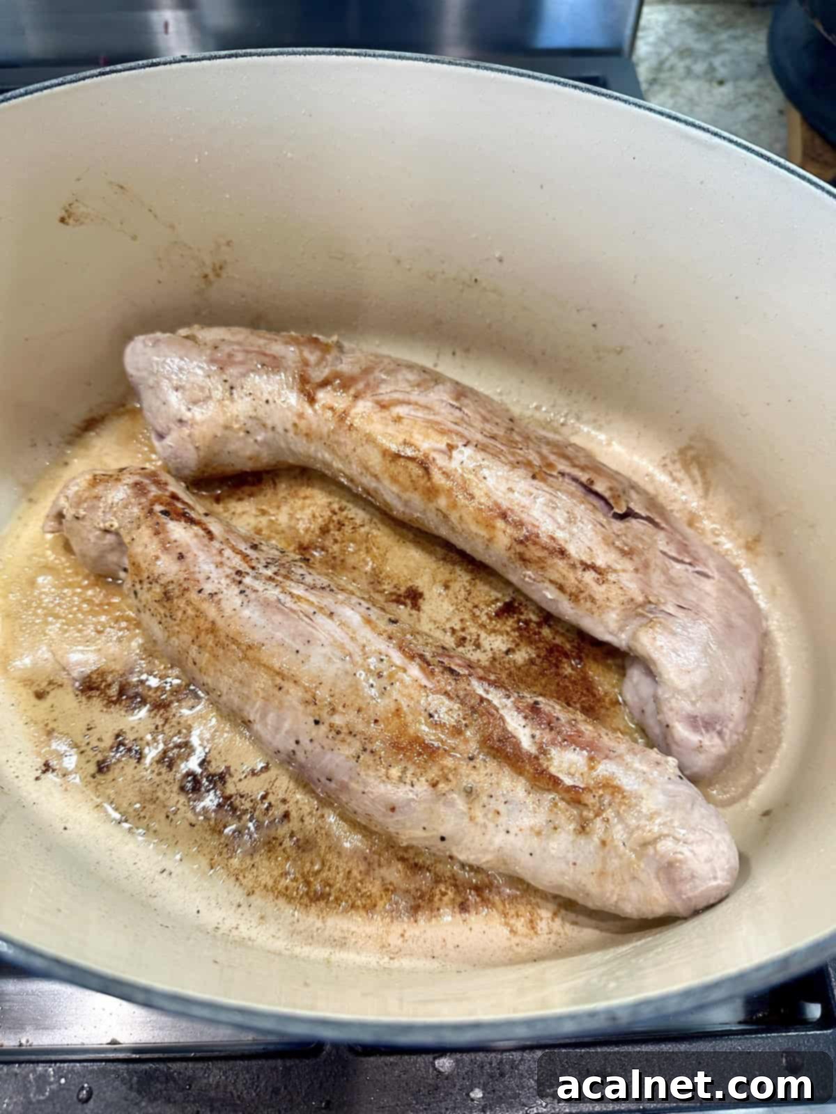 Cooked pork tenderloins in a pan.