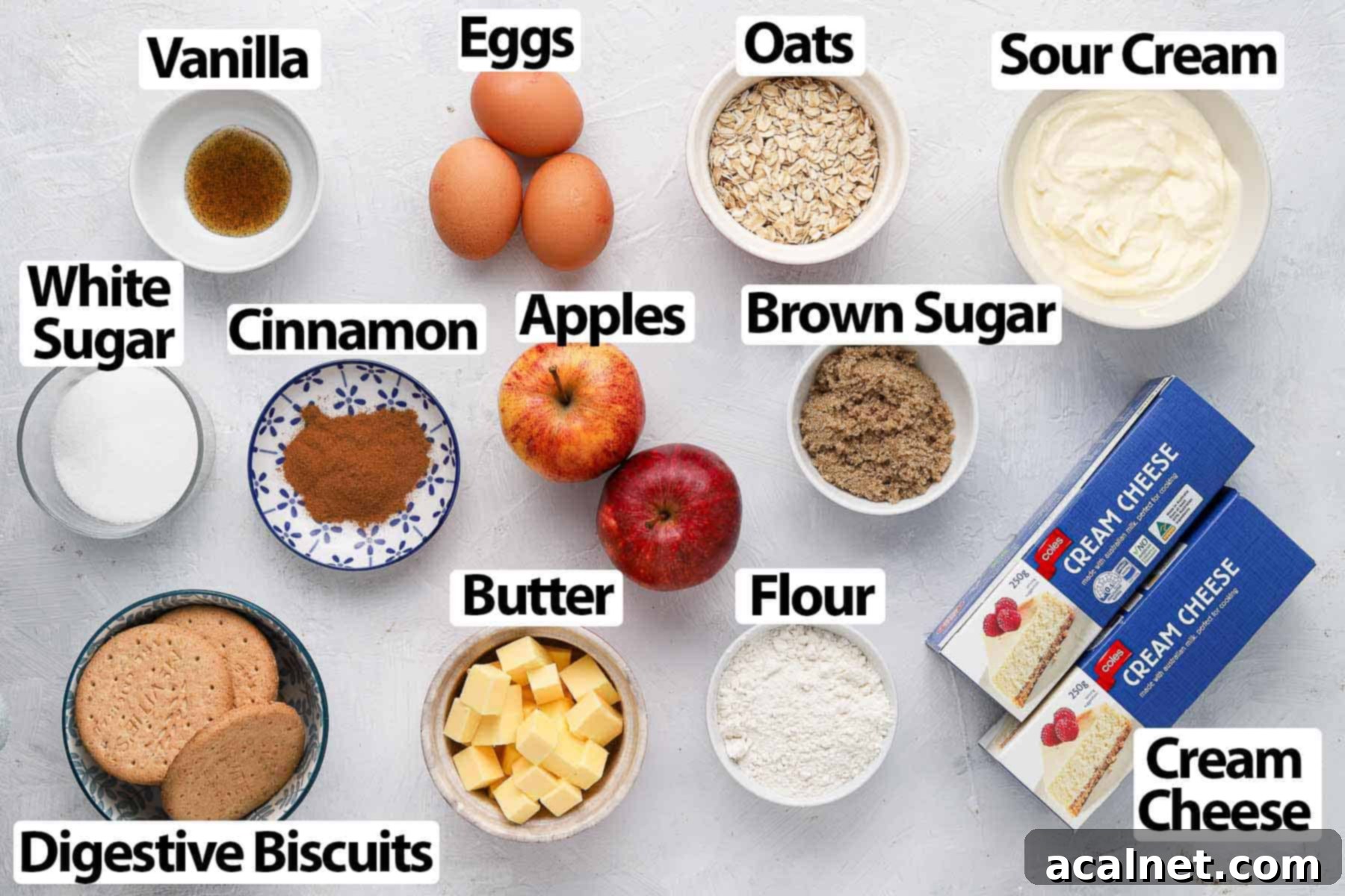 Spiced Apple Crumble Cheesecake 3 Various ingredients for apple crumble cheesecake laid out on a white surface.