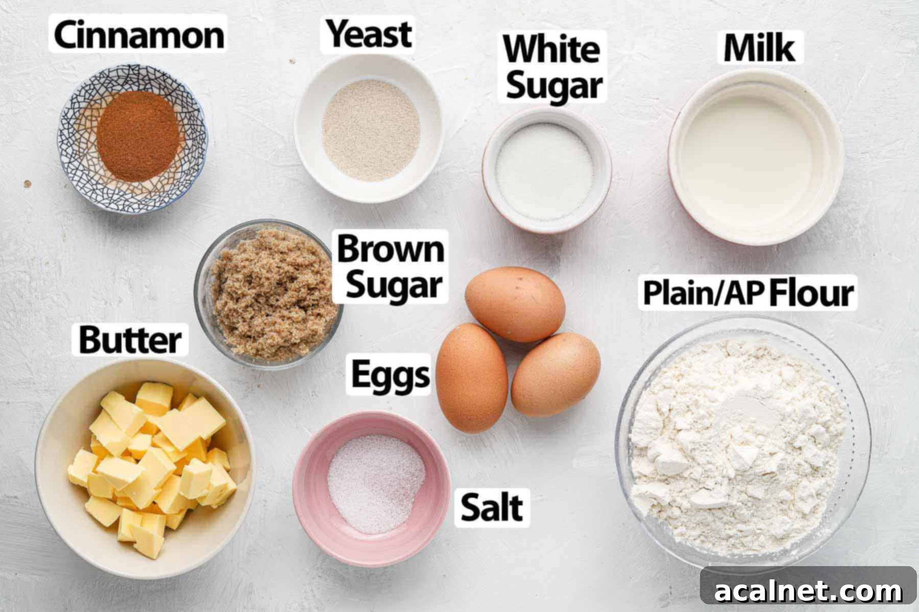 A flat lay photograph of various ingredients laid out on a white surface, ready for making Cinnamon Babka.