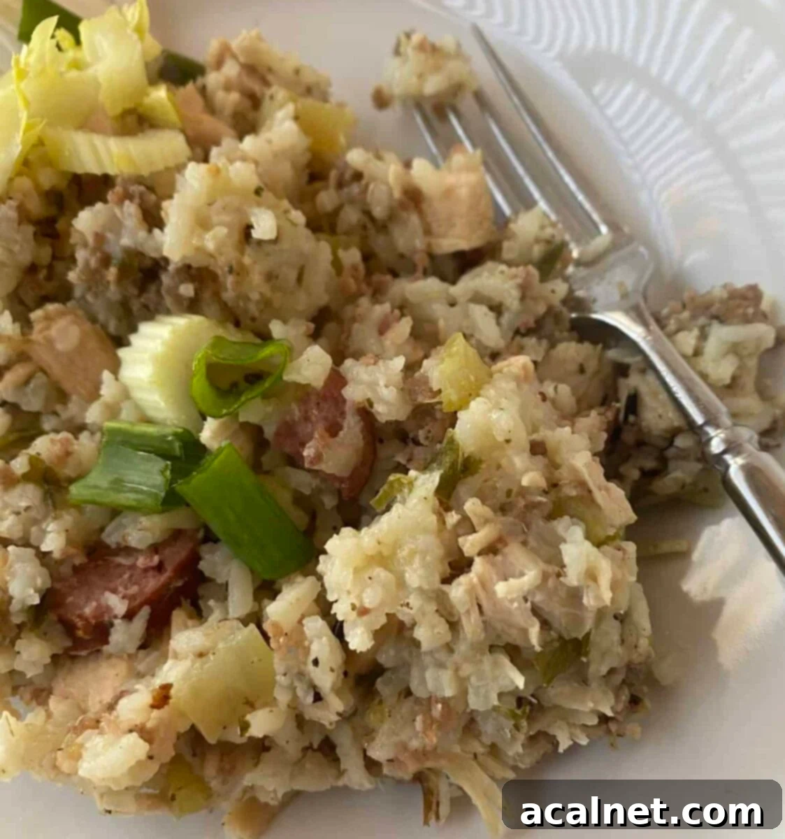 A scoop of jambalaya on a plate with a fork, ready to be enjoyed.