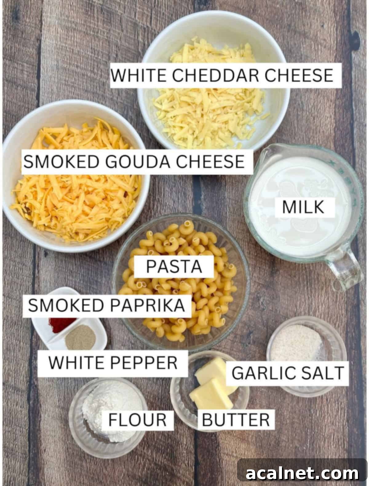 Smoked gouda mac and cheese ingredients in bowls on a wooden plank.